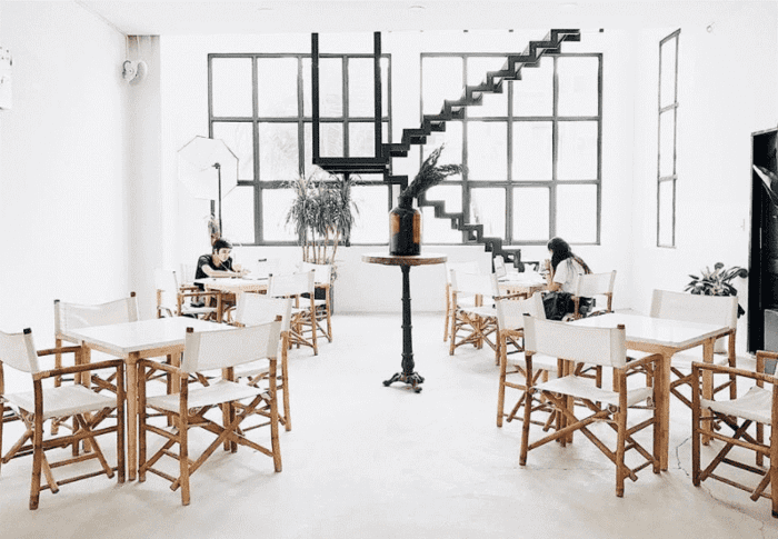 Mẫu thiết kế quán cafe đơn giản và trang nhã với gam màu trắng và nội thất kết hợp giữa gỗ và vải bố