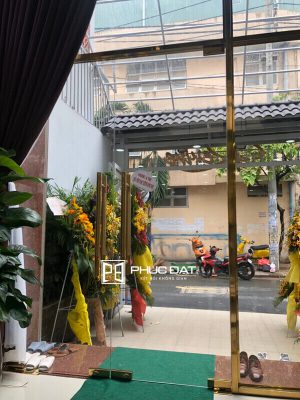 Cửa kính khung inox mạ vàng tiệm spa.