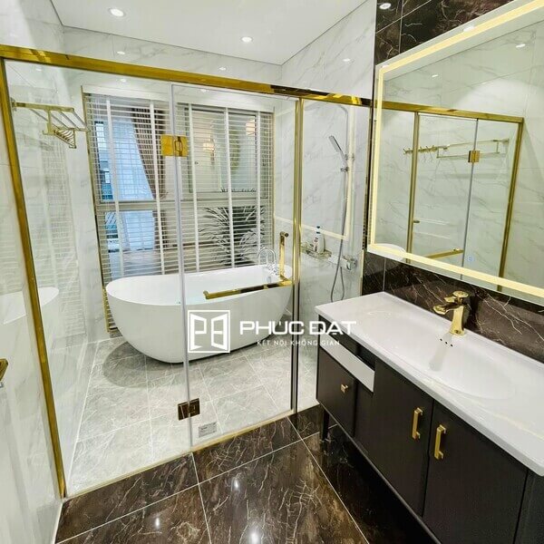 Mẫu nhà vệ sinh kính trong phòng ngủ đẹp sử dụng kính khung inox mạ vàng.